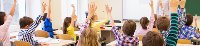 Classroom with students raising hands