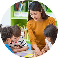 Teacher instructing three young students